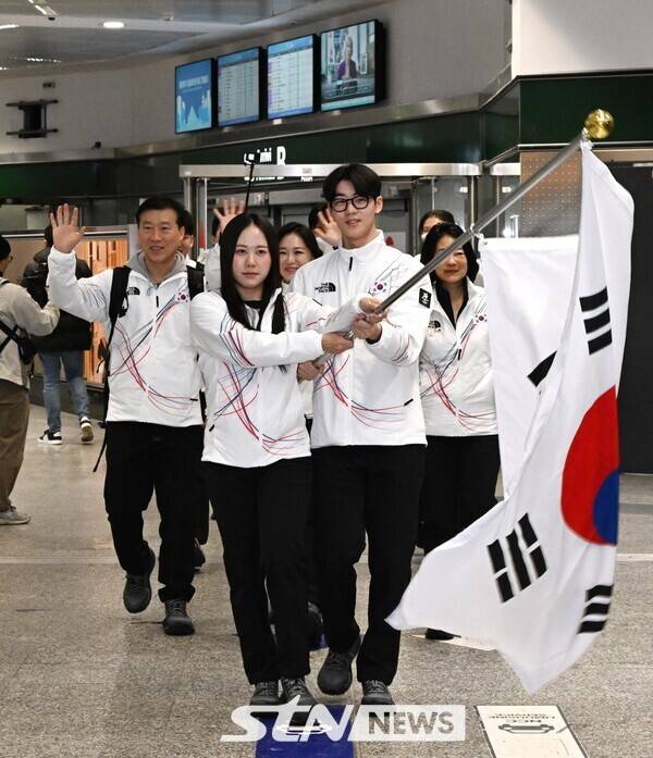 스피드스케이팅 박지우와 쇼트트랙 이준서가 2026 밀라노-코르티나담페초 동계올림픽 참가를 위해 밀라노에 입국하며 태극기를 흔들고 있다. /사진=뉴시스