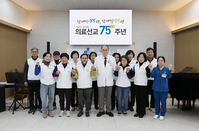 삼육부산병원이  지원 나온 지역 어르신과 기념촬영하고 있다.