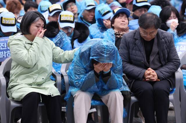 지난해 12월20일 오후 서울 종로구 보신각 광장에서 열린 1229 무안공항 제주항공 여객기 참사 1주기 서울시민추모대회에서 유가족 김영헌씨가 유가족 편지를 낭독하는 동안 유가족 옆에서 용혜인 의원이 눈물을 흘리고 있다. 김태형 기자 xogud555@hani.co.kr