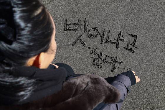 제주 마약치유센터에서 재활 중인 한 여성이 서귀포 해변가 모래밭에 '(마약의 유혹에서) 벗어나고 싶다’고 썼다. 김현동 기자