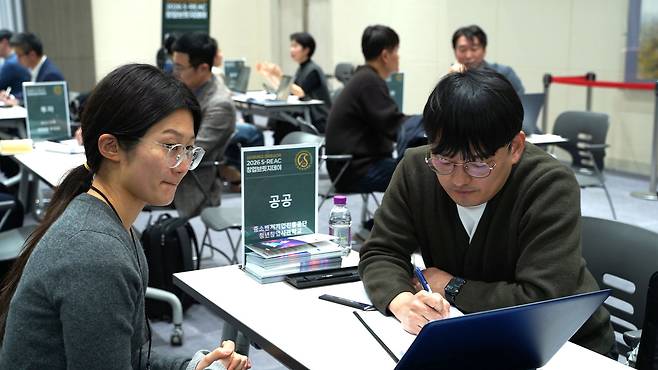 행사 참가자가 창업 전문가에게 일대일 멘토링을 받는 모습