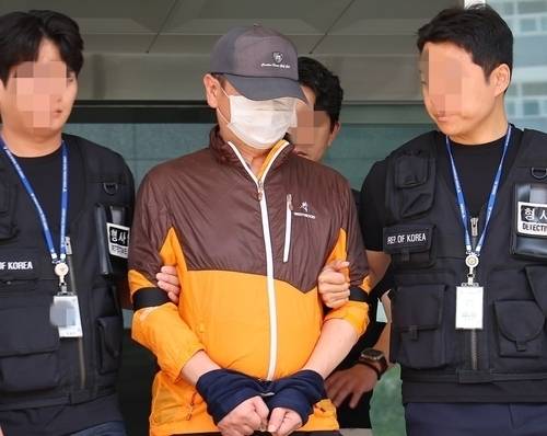 지난해 7월 인천 송도에서 사제 총기로 30대 아들을 살해한 60대 아버지가 인천 논현경찰서 유치장에서 구속상태로 검찰에 송치되고 있다. 연합뉴스 제공.