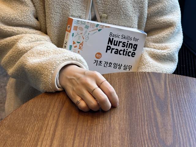 지난 1일 경기 지역 한 카페에서 만난 양서정(가명) 씨가 준비 중인 간호조무사 시험 교재를 들고 있다.  김지현 기자