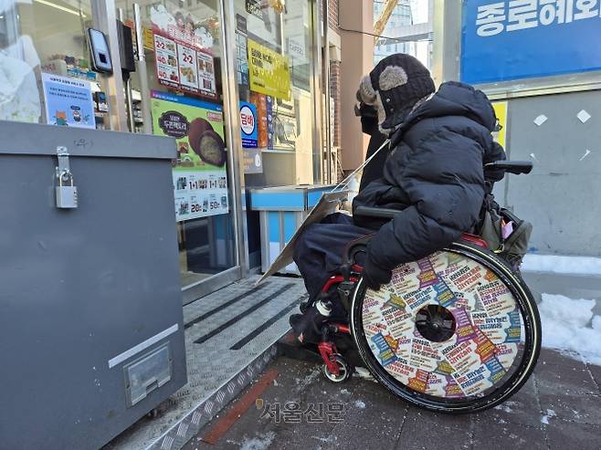 박경석 전국장애인차별철폐연대 상임공동대표가 지난 2일 서울 종로구의 한 편의점 입구에서 문턱에 가로막혀 들어가지 못하고 있다.