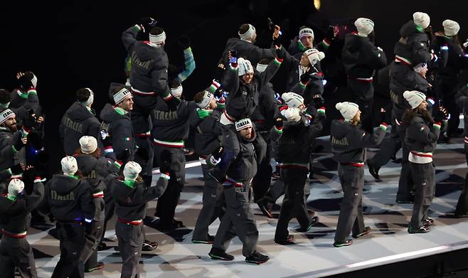 개최국 이탈리아 선수단이 아르마니의 스포츠 브랜드 EA7이 제작한 유니폼을 입고 2026 밀라노 코르티나담페초 동계올림픽 개회식에 입장하고 있다.