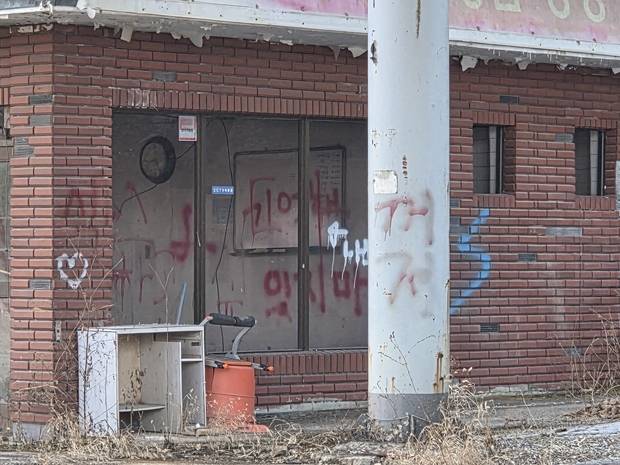 경기 남양주시 경춘로 한 폐주유소 벽에 페인트 스프레이로 낙서가 적혀 있다. 남양주=황동건 기자