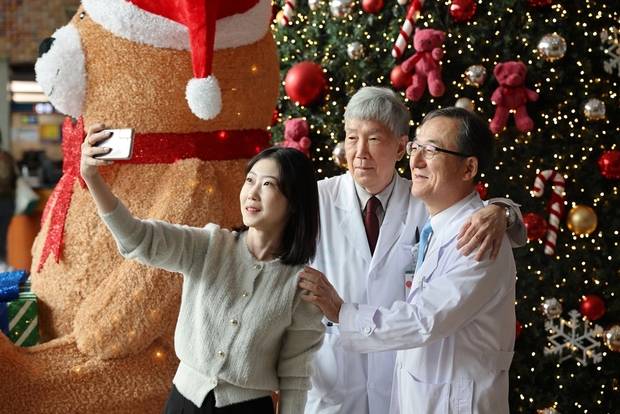 국내 첫 생체 간이식 주인공인 이지원(왼쪽) 씨가 당시 집도의였던 이승규 서울아산병원 간이식·간담도외과 교수(가운데)와 주치의인 김경모 소아소화기영양과 교수와 함께 30주년을 기념하며 사진을 찍었다. 사진 제공=서울아산병원