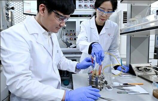 KIST가 그린수소 생산에서 촉매 사용량을 획기적으로 줄이는데 성공했다. 응우옌 퀸 프엉 박사후연구원(왼쪽)과 백새얀 학생연구원이 이리듐 촉매 반응을 시연 중이다.(사진=KIST)