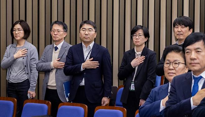 5일 국회에서 열린 더불어민주당 정책 의원총회에 공소청법·중수청법에 대한 정부안을 설명하기 위해 국무총리실 산하 검찰개혁추진단 관계자들이 국기에 경례하고 있다. 연합뉴스