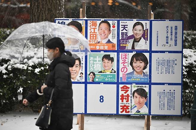 8일 일본 전역에서 중의원 투표가 진행된 가운데 한 시민이 후보자 벽보 앞을 지나가고 있다. [AFP = 연합뉴스]