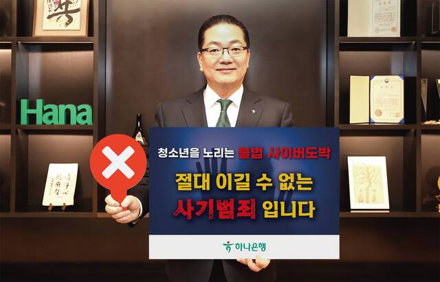 이호성 하나은행장이 서울 중구 하나은행 을지로 본점에서 청소년 불법도박 근절 릴레이 캠페인에 동참하기 위해 '청소년을 노리는 불법 사이버 도박, 절대 이길 수 없는 사기 범죄입니다'라는 메시지를 담은 피켓을 들고 사진을 촬영하고 있다. /하나은행