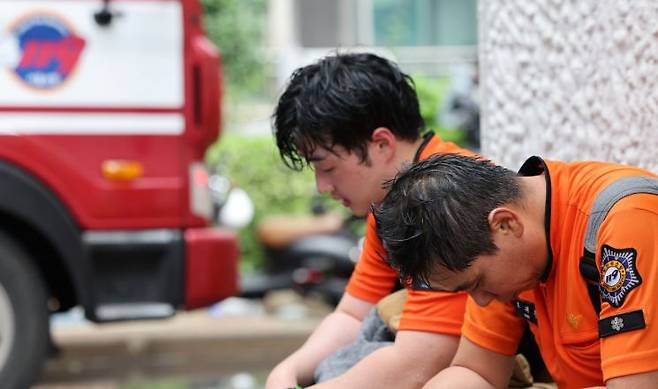 지난해 8월 서울의 한 아파트 화재현장에서 소방대원들이 진화작업 도중 잠시 휴식을 취하고 있다. 연합뉴스