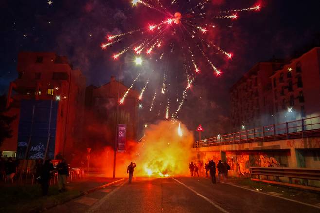 2월 7일 오후(현지시간) 이탈리아 밀라노에서  '지속 불가능한 올림픽 위원회'가 주최한 올림픽 반대 집회가 열렸다. 이번 집에는 그린피스 등 단체가 연합해 밀라노 메달리에 도로(piazza medaglie d'oro)에서 시작해 시내 곳곳을 행진한 뒤 코르베토역 인근 도로에서 홍염을 피우며 경찰 차벽을 향해 불꽃과 벽돌 그리고 유리병을 던졌다. 이날 시위로 시위대 6명이 경찰에 체포 됐다. 시위대가 구호를 외치며 경찰 차벽을 향해 불꽃을 쏘고 있다. 밀라노=장련성 기자