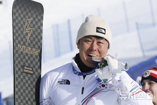 [리비뇨=뉴시스] 김근수 기자 = 스노보드 은메달리스트 김상겸이 8일(현지 시간) 이탈리아 리비뇨 스노우파크에서 열린 2026 밀라노코르티나 담페초 동계올림픽 스노보드 남자 평행대회전 메달 시상식에서 은메달을 입에다 물고 있다. 2026.02.08. ks@newsis.com
