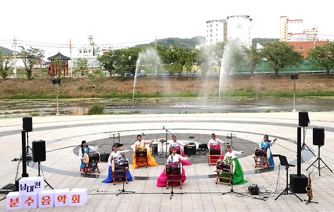 ▲ 경북 의성군 의성읍 남대천 음악분수 광장에서 전통 복장을 갖춘 연주자들이 야외 국악 공연을 진행하는 가운데 분수 시설과 음향 장비가 함께 운영되고 있다. 의성군