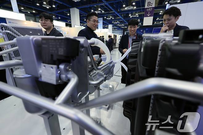 지난 2025년 12월3일 서울 강남구 삼성동 코엑스에서 열린 2025 코리아 테크 페스티벌 한온시스템(주) 부스를 찾은 바이어가 관계자에게 하이브리드 히트펌프 시스템에 대한 설명을 듣고 있다. 2025.12.3 ⓒ 뉴스1 박정호 기자