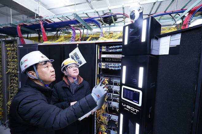 LG유플러스 직원이 AI 자율주행 로봇 ‘U-BOT’을 소개하는 모습.(LG유플러스 제공)