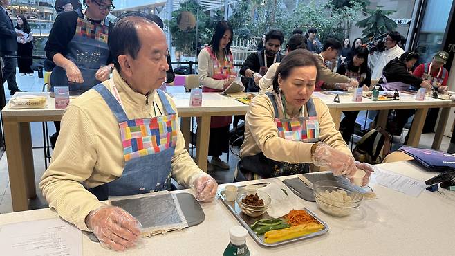 Gus Dimaano and his wife make their own gimabp during cooking-class. [WOO JI-WON]