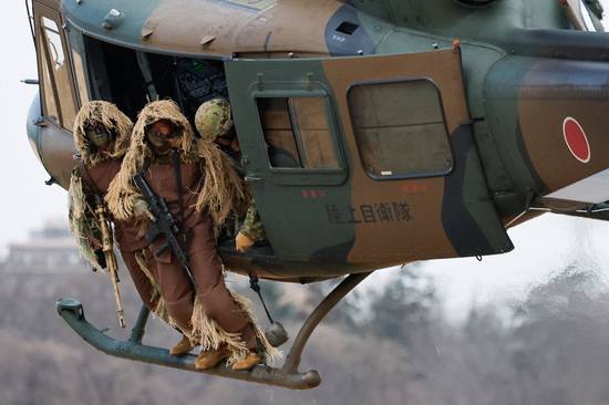 헝겊조각이나 나뭇가지, 앞사귀 등으로 주변 자연물과 동화되도록 만든 야전 위장복인 길리 수트를 입은 일본 육상자위대 제1공수여단 저격수들이 도쿄 인근에서 열린 훈련 중 핼기를 타고 이동하고 있다. /사진=로이터