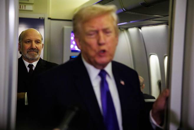 하워드 러트닉 미국 상무부 장관(왼쪽)이 지난 6일 플로리다주 팜비치로 향하는 에어포스 원 기내에서 도널드 트럼프 미국 대통령이 기자들의 질문에 답하는 모습을 지켜보고 있다.[AFP]