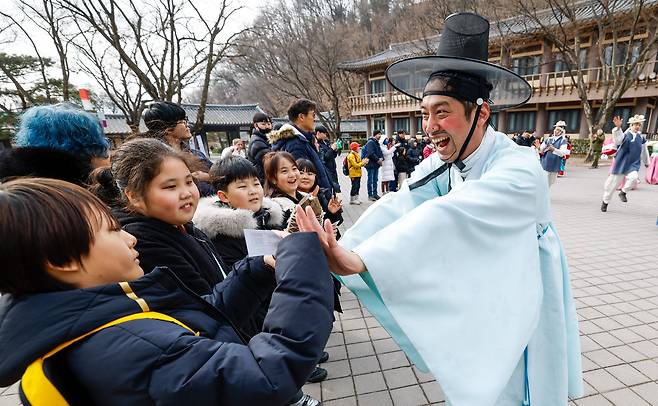 설 연휴를 앞둔 10일 경기 용인시 한국민속촌에서 관람객들이 민속 퍼레이드 공연 ‘백년가약’을 지켜보고 있다.&nbsp;