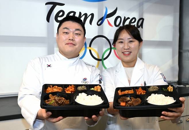 9일(현지시간) 이탈리아 밀라노에서 열린 대한체육회가 운영하는 급식지원센터 공개 미디어행사에서 김중현 조리장과 조은영 영양사가 국가대표팀 선수들에게 전달한 도시락을 들고 포즈를 취하고 있다. 대한체육회 제공