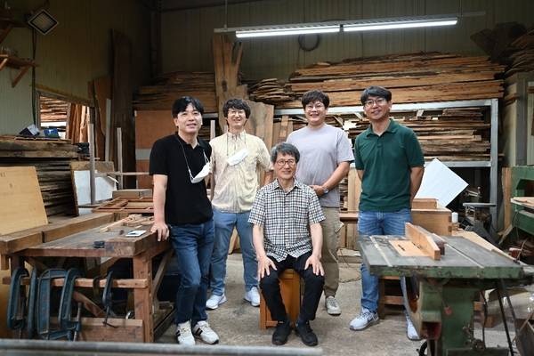 경상남도 무형유산 소목장 정진호 보유자가 작은아들이자 전승교육사인 정연오(맨 오른쪽) 씨, 이수자들과 함께 기념촬영을 하고 있다. /정연오