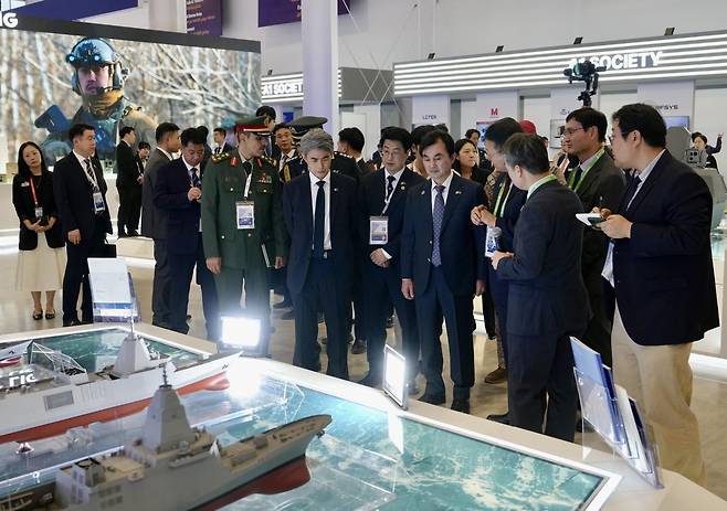 안규백 국방부 장관이 8일(현지시간) 사우디아라비아 수도 리야드에서 열린 '국제방산전시회(WDS) 2026' HD현대중공업 부스를 방문해 관계자의 설명을 듣고 있다. 한국방위산업진흥회 제공
