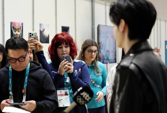 올림픽 자원봉사자들이 이탈리아 밀라노 메인프레스센터에서 대한체육회 홍보대사로 현지를 찾은 엔하이픈 멤버 성훈을 촬영하고 있다. 뉴시스