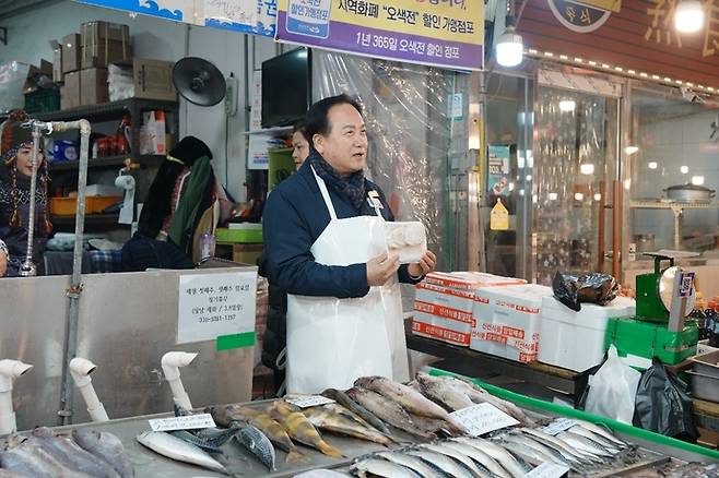 지난 10일 이권재 오산시장이 오산 오색시장의 한 생선가게에서 하얀색 앞치마를 두르고 생선을 판매하고있다. 사진=오산시청