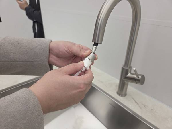 삼성전자로지텍 직원이 전용 수압측정기를 수도꼭지에 연결해 수압을 측정하는 모습을 시연하고 있다. 사진=신혜영 이코노믹리뷰 기자