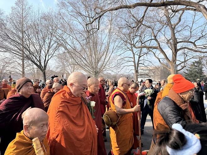 11일(현지시각) 오전 ‘평화를 위한 걷기(Walk for Peace)’ 순례단이 미 국회의사당 앞을 지나갈 때 첫 한국계 연방상원의원인 앤디 김(민주당·뉴저지)이 꽃을 나눠주고 있다. 워싱턴/김원철 특파원