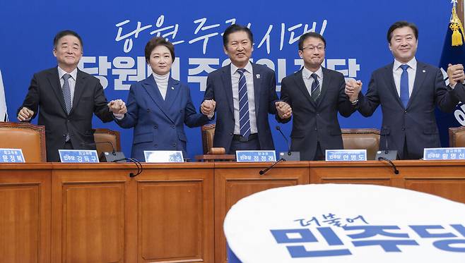 더불어민주당 정청래 대표, 한병도 원내대표를 비롯한 최고위원들이 지난 11일 국회에서 열린 최고위원회의에 입장해 서로 손을 잡고 인사하고 있다. 연합뉴스.