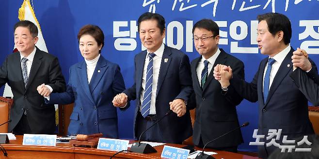 더불어민주당 정청래 대표와 이언주 최고위원을 비롯한 지도부가 11일 서울 여의도 국회에서 열린 최고위원회의에서 앞서 손을 잡고 있다. 윤창원 기자