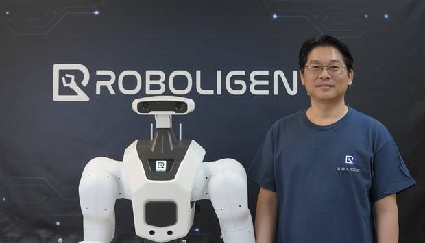 김봉수 로볼리전트 대표가 미국 텍사스주에 위치한 로볼리전트 사무실에서 휴머노이드 로봇 ‘로빈’과 함께 사진을 촬영하고 있다. 사진 제공=로볼리전트