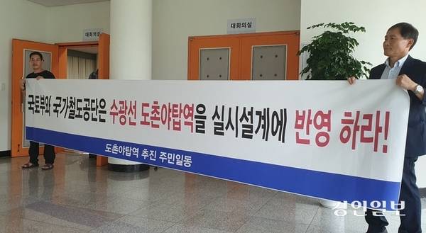 국가철도공단이 지난 2024년 8월 개최한 ‘수서~광주 복선전철 환경영향평가서 설명회’에서 주민들이 도촌야탑역 신설을 요구하는 플래카드를 들고 있는 모습. /경인일보DB