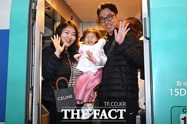 13일 서울 용산구 용산역에서 귀성길에 오르는 한 가족이 손을 흔들고 있다. /남용희 기자