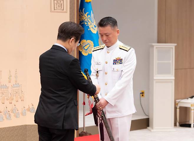 이재명 대통령이 지난해 9월 2일 서울 용산 대통령실 청사에서 열린 대장 진급·보직 신고 및 삼정검 수치 수여식에서 해군참모총장 강동길 대장의 삼정검에 수치를 달아주고 있다. (대통령실 제공. 재판매 및 DB 금지) 2025.9.2/뉴스1