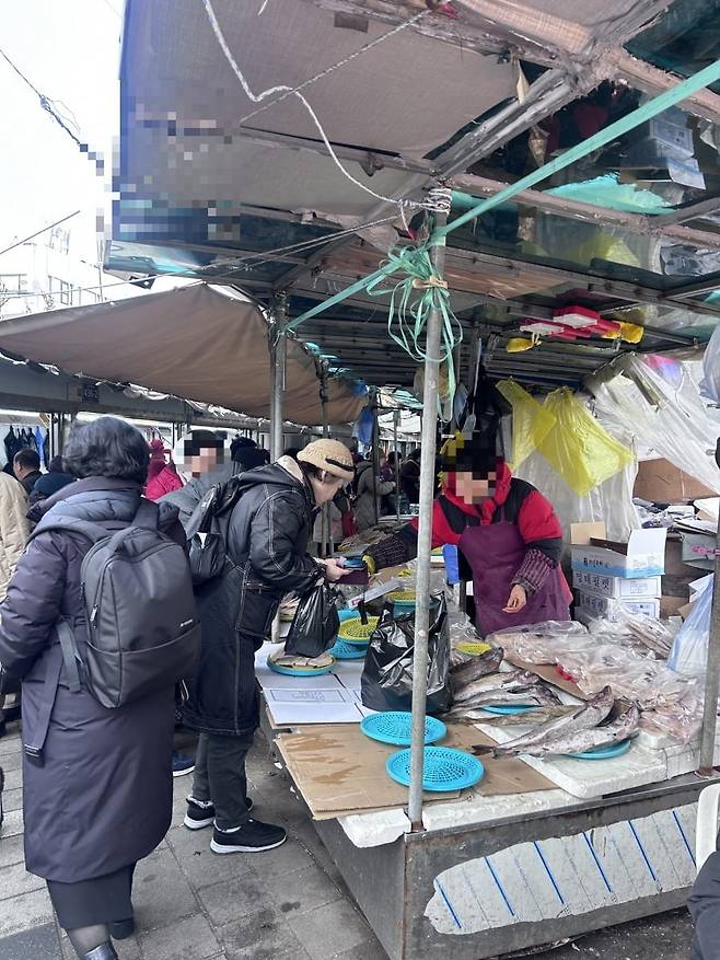서울 제기동 경동시장에 있는 생선가게에서 시민이 생선을 구매하는 모습/ 사진 = 이소이 기자