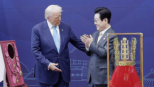 President Lee Jae Myung, right, presents U.S. President Donald Trump with the Grand Order of Mugunghwa and a model of the Cheonmachong gold crown at the Gyeongju National Museum in Gyeongju, North Gyeongsang, on Oct. 29. [JOINT PRESS CORPS]