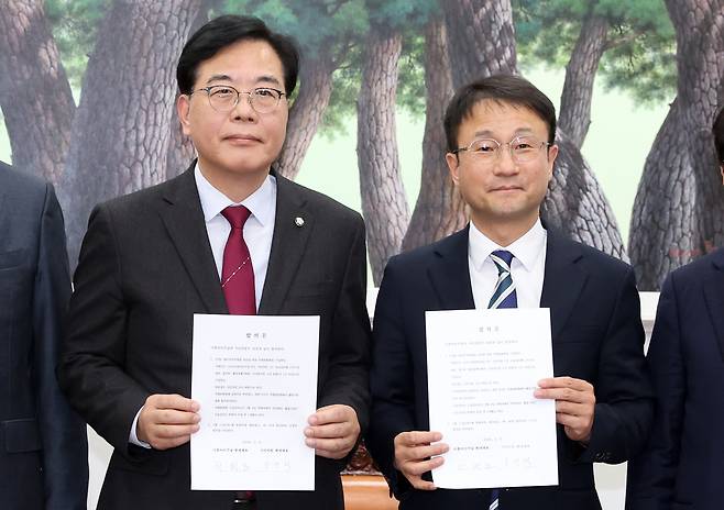 Conservative People Power Party floor leader Song Eon-seog, left, and liberal Democratic Party floor leader Han Byung-do, hold an agreement on the formation of the special committee to pass the special act on Korea's investment to the United States at the National Assembly in western Seoul on Feb. 4. [NEWS1]