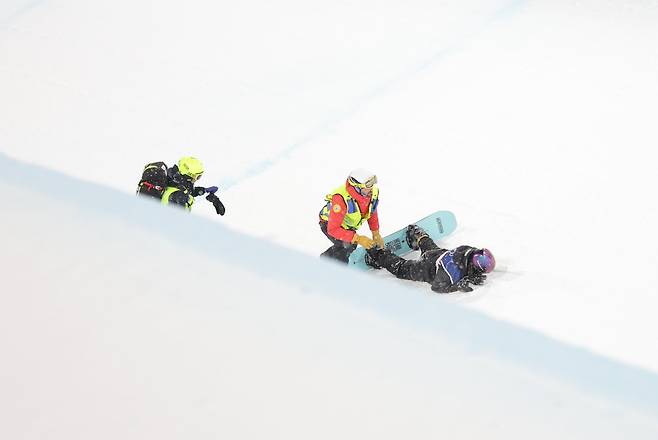 Choi Ga-on falls and is tended by the medical team on Feb. 12 at the 2026 Milan-Cortina Winter Olympics. [YONHAP]