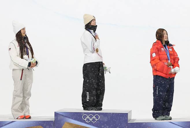 Snowboarder Choi Ga-on, center, stands on the podium on Feb. 12 after winning the gold medal at the 2026 Milan-Cortina Winter Olympics. [YONHAP]