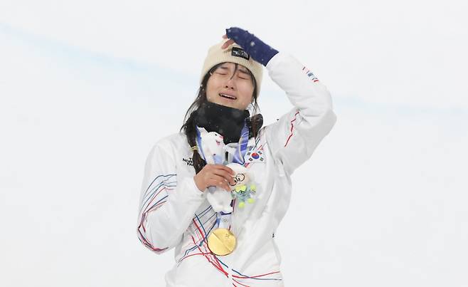 12일(현지시간) 이탈리아 리비뇨 스노파크에서 열린 2026 밀라노·코르티나담페초 동계 올림픽 스키 스노보드 여자 하프파이프 결선에서 90.25점으로 정상에 오른 한국 최가온이 금메달을 목에 건 뒤 눈물을 흘리고 있다. 연합뉴스