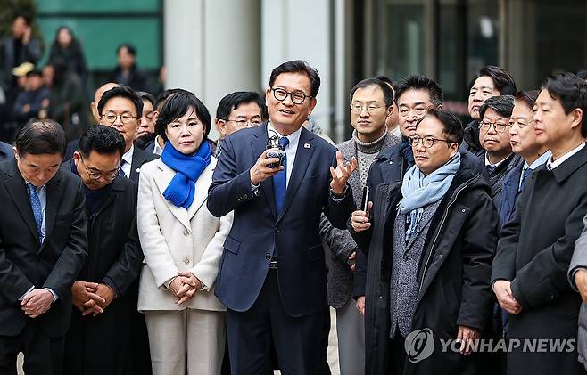 소나무당 송영길 대표, '돈봉투 의혹' 항소심 무죄 판결 (서울=연합뉴스) 더불어민주당 전당대회 '돈봉투 살포' 의혹과 불법 정치자금 수수 혐의로 재판에 넘겨진 소나무당 송영길 대표가 13일 서초구 서울고등법원에서 열린 2심 선고 공판에서 무죄를 선고 받은 뒤 더불어민주당 의원들과 법원 청사 앞에 서서 입장을 밝히고 있다. 2026.2.13 [소나무당 제공. 재판매 및 DB 금지] photo@yna.co.kr