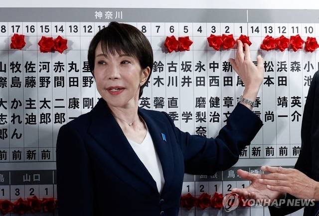 다카이치 사나에 일본 총리가 지난 2월 8일 중의원 선거(총선)에서 승리한 집권 자민당 후보 이름 위에 꽃을 붙이고 있다.[로이터 연합뉴스]