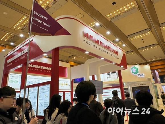 세미콘코리아 2026 전시장에서 '스튜던트 가이드 투어'에 참여한 대학생들이 하마마츠 부스를 둘러보고 있다. 이번 투어는 홍상진 명지대 반도체공학과 교수가 15년간 이어온 현장 안내 활동을 바탕으로, 세미콘코리아와 처음 공동 운영한 대학생 대상 프로그램이다. [사진=권서아 기자]