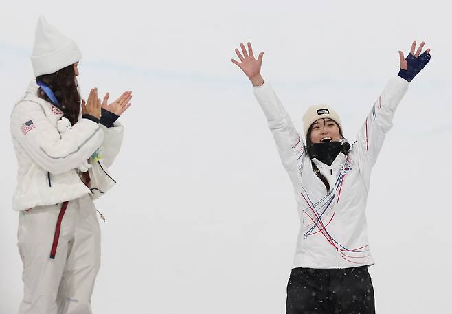 12일(현지시간) 이탈리아 리비뇨 스노파크에서 열린 2026 밀라노-코르티나담페초 동계올림픽 스노보드 여자 하프파이프 결승에서 금메달을 따낸 최가온이 시상대에 오르며 기뻐하고 있다. 왼쪽은 은메달을 딴 미국 클로이 김. 2026.2.13 연합뉴스
