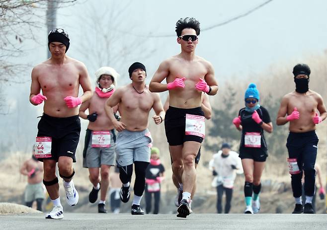 Participants run shirtless on Saturday during the Pyeongchang Daegwallyeong Naked Marathon, held in Pyeonchang, Gangwon Province. (Newsis)