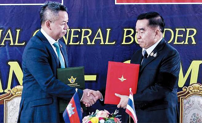 지난해 12월 27일 오후 태국 찬타부리주 프룸-반팍카드 국경검문소에서 낫타폰 낙파니트(오른쪽) 태국 국방 장관과 티아 세하 캄보디아 부총리 겸 국방 장관이 양국 간 휴전 합의 후 악수하고 있다. 양국은 이날 낮 12시를 기해 지난 7일부터 이어진 전쟁을 멈추기로 합의했다. /AFP 연합뉴스